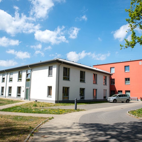 Ein weißes Gebäude vor einem roten Gebäude